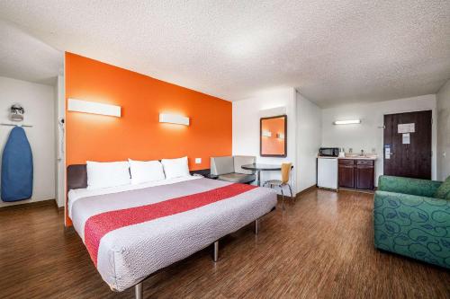 Cama grande en habitación con pared de color naranja en Clarion Pointe - Near Grand Canyon en Williams