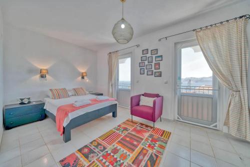 a bedroom with a bed and a pink chair at Villa Pilu in Kaş