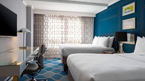 a hotel room with two beds and a tv at The Ven at Embassy Row, Washington, D.C., a Tribute Portfolio Hotel in Washington