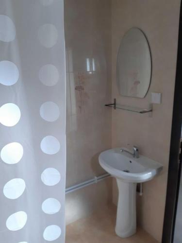 a white bathroom with a sink and a mirror at Cabana Valea Arieșului in Arieşeni