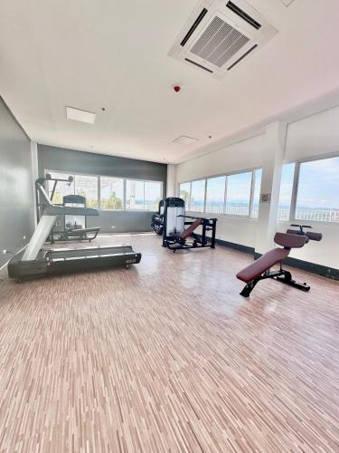 a gym with treadmills and exercise equipment in a room with windows at Scandinavian 1 BR beside SM CDO w POOL and Netflix in Cagayan de Oro