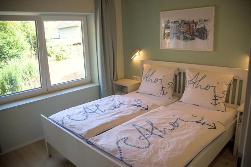 a bed with writing on it in a bedroom at Landhaus PHILIPP - Ostsee FeWo's in Nienhagen