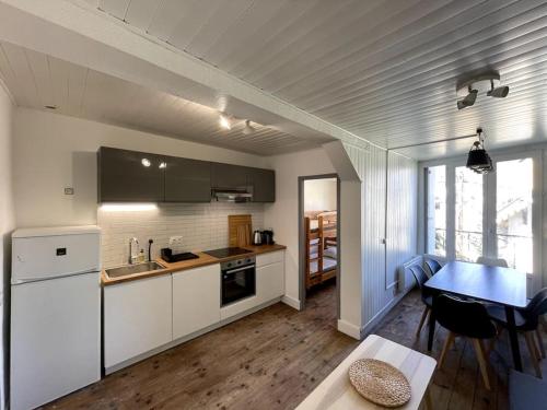 een keuken met witte kasten en een tafel en een eetkamer bij Villa Narcisse in Luchon