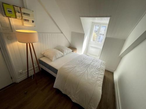 een slaapkamer met een wit bed en een raam bij Villa Narcisse in Luchon