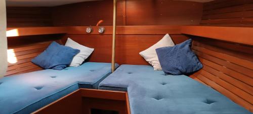 a seat in a boat with blue and white pillows at One day Sailing Tour San Teodoro Sardinia in Puntaldia