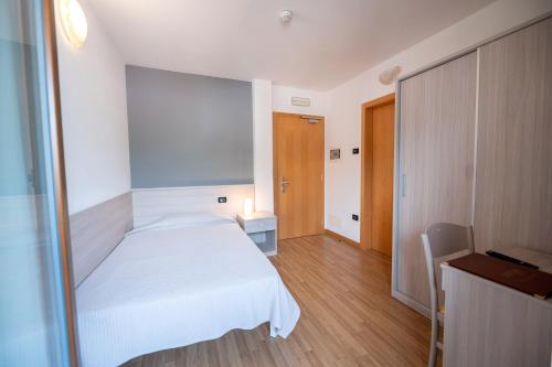 a bedroom with a white bed in a room at Hotel Posta in Comano Terme