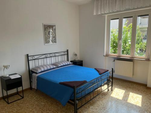 um quarto com uma cama azul e 2 janelas em Camere Giulia em Bérgamo