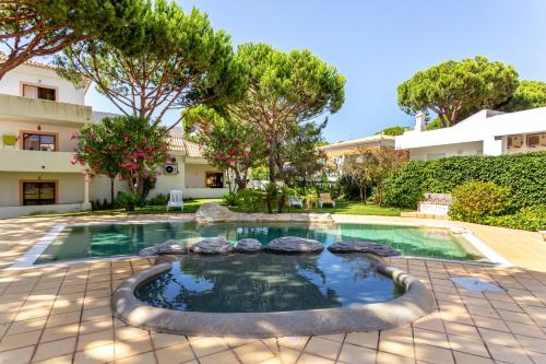 einen Pool in einem Garten mit Bäumen in der Unterkunft Fresh Sunny Flat with Pool & Terrace by Host Wise in Olhos de Água