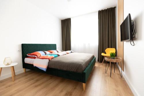 1 dormitorio con 1 cama y TV de pantalla plana en Emerald Apartment en Baia Mare