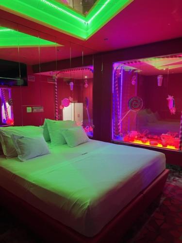 a bedroom with a bed with green and purple lights at V Hotel in Arroyomolinos