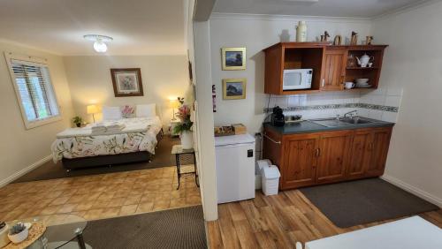 cocina y dormitorio con cama y lavamanos en Riesling Trail & Clare Valley Cottages en Clare