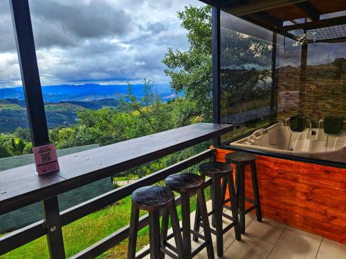 a bar with stools and a view of a bath tub at Glamping Hakuna Matata in Monguí