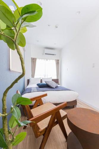 a bedroom with a bed and a table and a plant at Pufuka Hikifune ぷふか曳舟 in Tokyo
