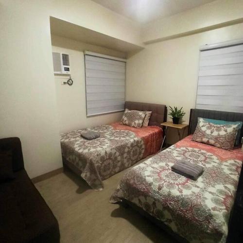 Zimmer mit 2 Betten in einem Zimmer in der Unterkunft Spacious 2BR in Araneta Center Cubao Pet Friendly in Manila