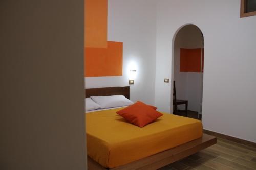 Dormitorio con cama con almohada naranja en Zia Bianca BeB, en Vietri