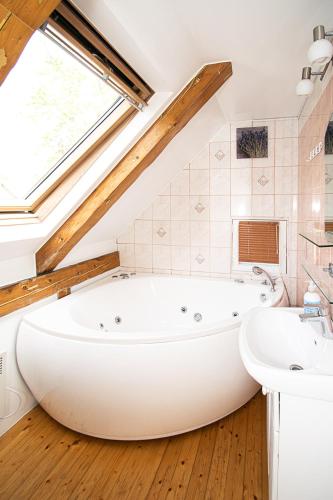 a large white bath tub in a bathroom with a window at Kerese Apartments in Pärnu