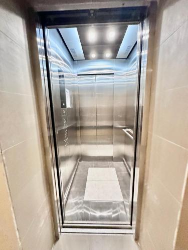 cabina doccia con porta in vetro in bagno di Aesthetic One Bedroom Beside SM w Pool, Wifi and Netflix a Cagayan de Oro