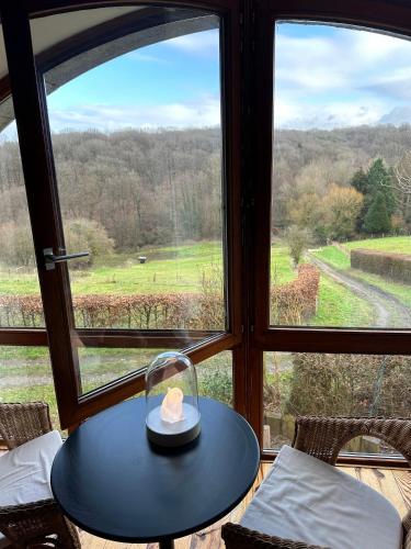 a table with a candle on it in front of a window at Les deux chambres au dessus de la colline in Namur