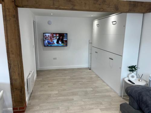 a kitchen with a refrigerator and a tv on the wall at Acorn Lodge in Eastergate