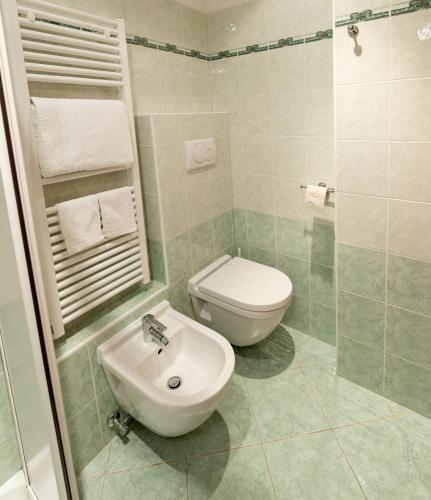 a bathroom with a toilet and a sink at Hotel Posta in Comano Terme