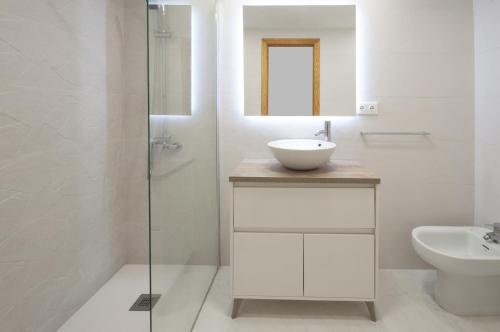 Baño blanco con lavabo y espejo en Begonia, en Daimuz