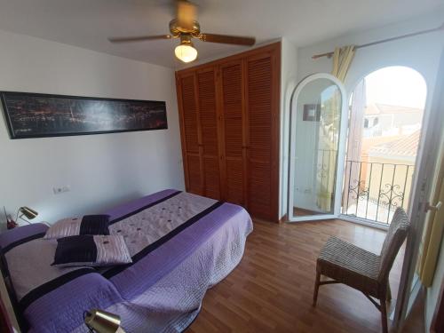 a bedroom with a purple bed and a balcony at Cabo de Palos VVMU 4780-1 in Cabo de Palos