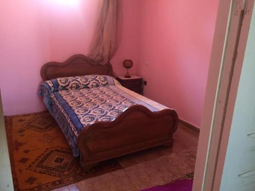 ein Schlafzimmer mit einem Bett in einem rosa Zimmer in der Unterkunft Villa Said in Moulay Bousselham