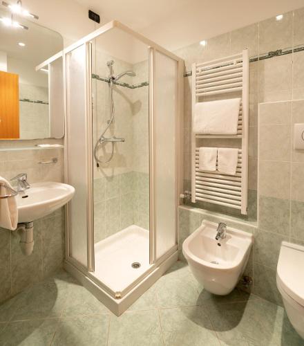 a bathroom with a shower and a sink and a toilet at Hotel Posta in Comano Terme
