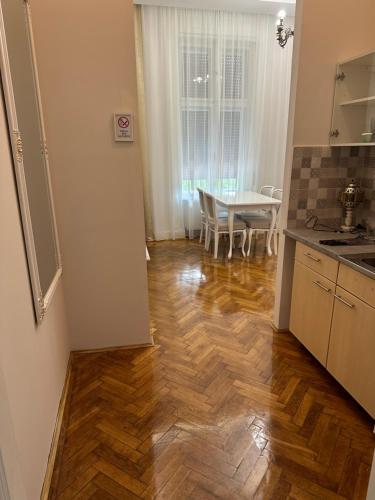 a kitchen with a wooden floor and a table at Apartments & Room - Korzo in Sombor