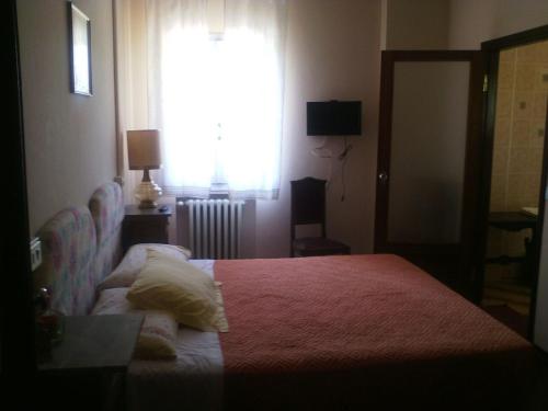 a bedroom with a bed with a red blanket and a window at Villa Montrona RR in Imola