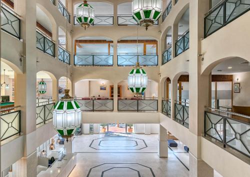 an open lobby with large windows and chandeliers at Bahía Tropical in Almuñécar