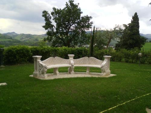 a white bench sitting in a field of grass at Villa Montrona RR in Imola