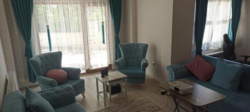 a living room with blue chairs and a couch at TERMAL LUX HOUSE in Yalova