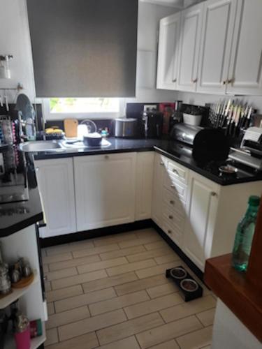 a kitchen with white cabinets and a black counter top at Villa Coma in Denia