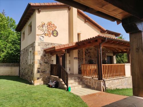 a house with a porch with a deck at Los Robles I in Sotillo del Rincón