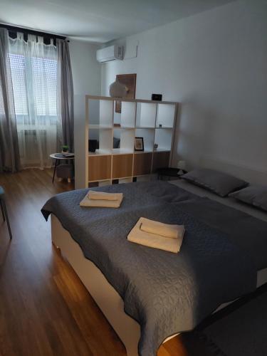 una camera da letto con un grande letto con due asciugamani di M&M Apartment a Velika Gorica