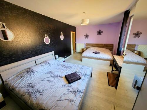 a bedroom with two beds and purple walls at Au Vendangeoir chambres d'hôtes in Couvignon