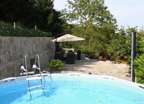 una piscina en un patio con sombrilla en Holiday House Žalec, 