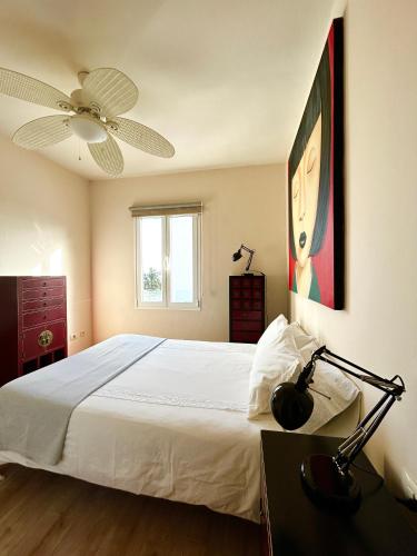 a bedroom with a white bed and a ceiling fan at APARTAMENTO PAULA in San Miguel de Abona
