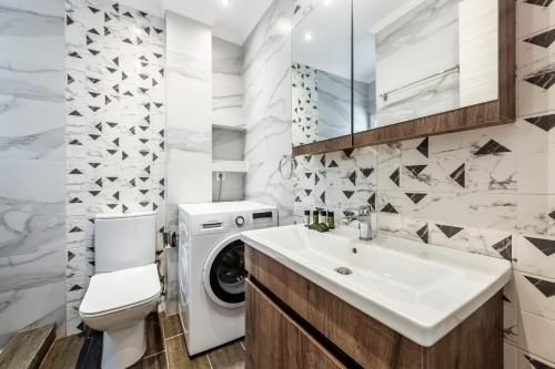 a bathroom with a washing machine and a white sink at Phaedrus Living Athens City Center Geraniou in Athens