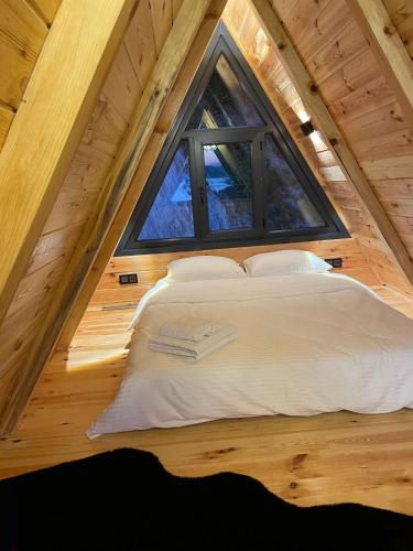 uma cama numa pequena casa com uma janela em CİVRA BUNGALOV em Sürmene