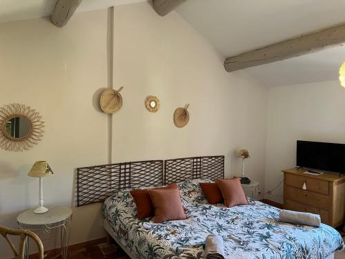 um quarto com uma cama com almofadas em Domaine La Condamine CRILLON LE BRAVE em Crillon-le-Brave