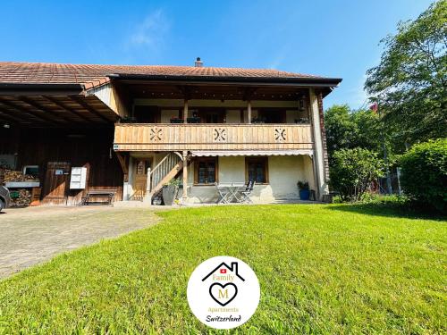 a large building with a sign in the grass at Family M Apartments 15 in Kappel bei Olten