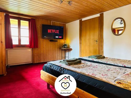 a room with two beds and a television in it at Family M Apartments 15 in Kappel bei Olten