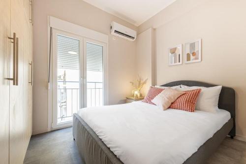 sypialnia z łóżkiem z białą pościelą i oknem w obiekcie Phaedrus Living Athens City Center Geraniou w Atenach