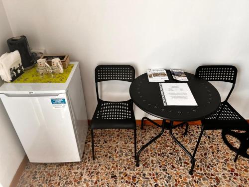 a black table and two chairs in a room at Camere Giulia in Bergamo