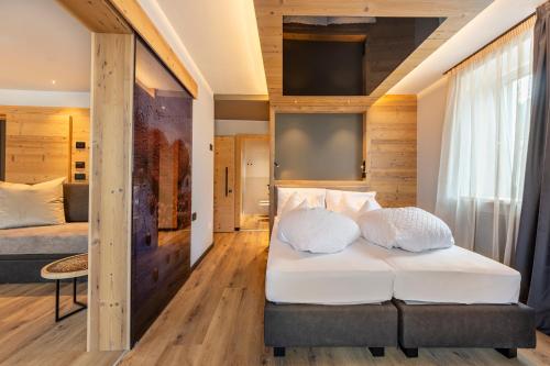 a bedroom with a bed with white pillows on it at Suite del Podesta' in Moena