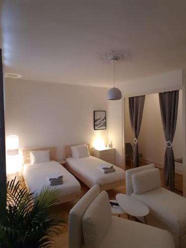 ein Hotelzimmer mit 2 Betten und einem Sofa in der Unterkunft DIAMOND appartement au centre de Genève in Genf