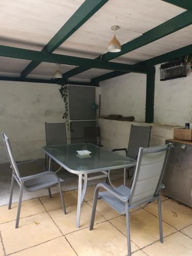 Una mesa y cuatro sillas en una habitación en Charmantes Haus mit Terrasse und großem Garten, en Langenzersdorf