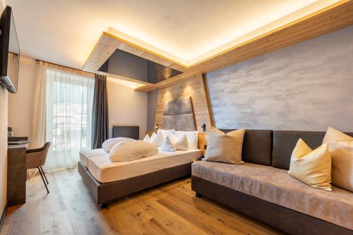 - un salon avec un canapé et un lit dans l'établissement Suite del Podesta', à Moena